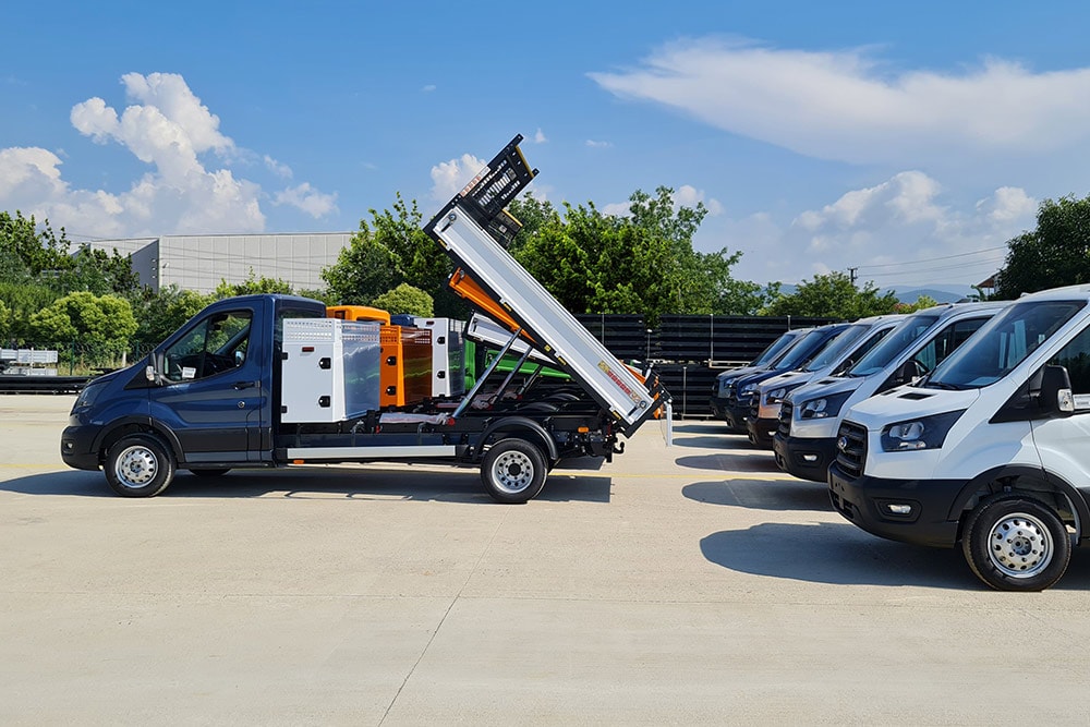 A fleet of Ford E-Transit Skeletal Chassis vehicles parked in a lot.