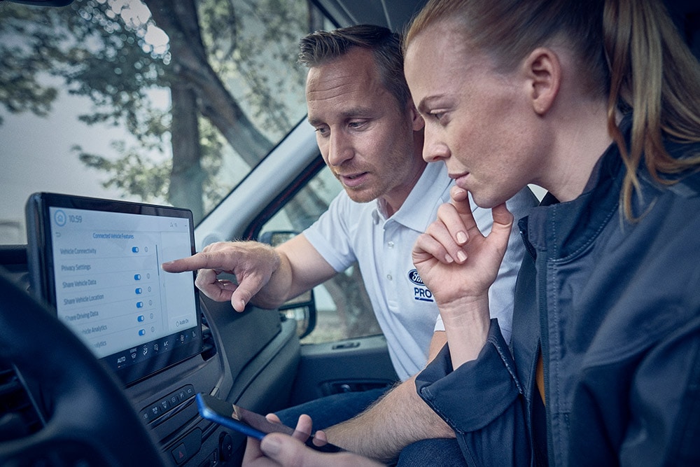 Ford advisor and customer connecting van to FordPass Pro app on in-vehicle control screen.