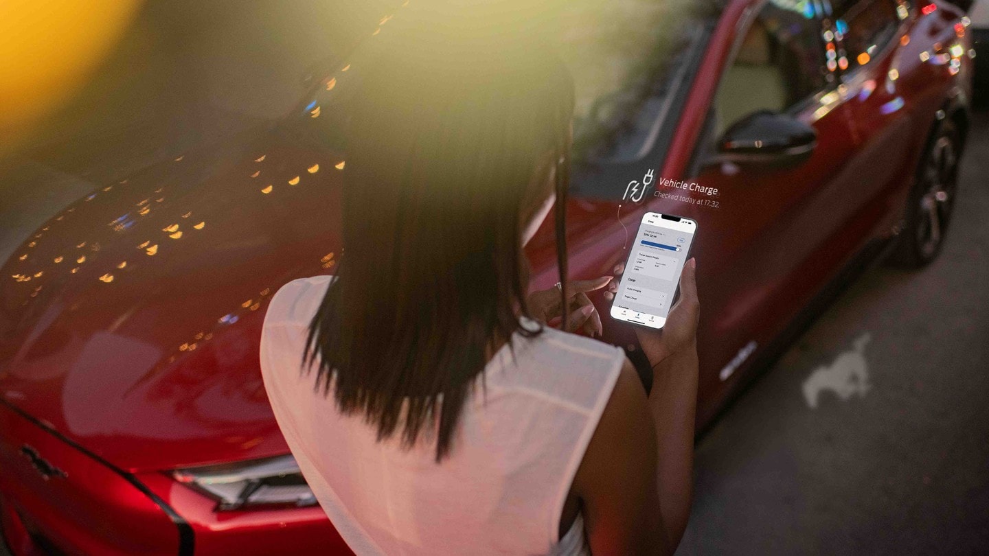 Woman looking at smartphone with Ford app displayed