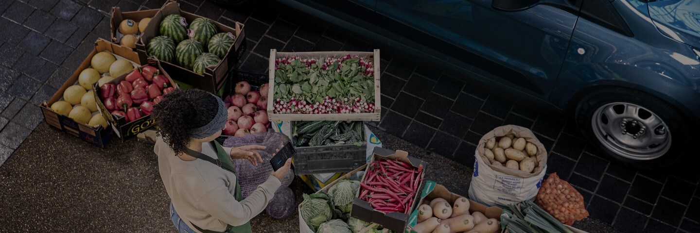 Bird's eye view of vendor selling boxes of vegetables