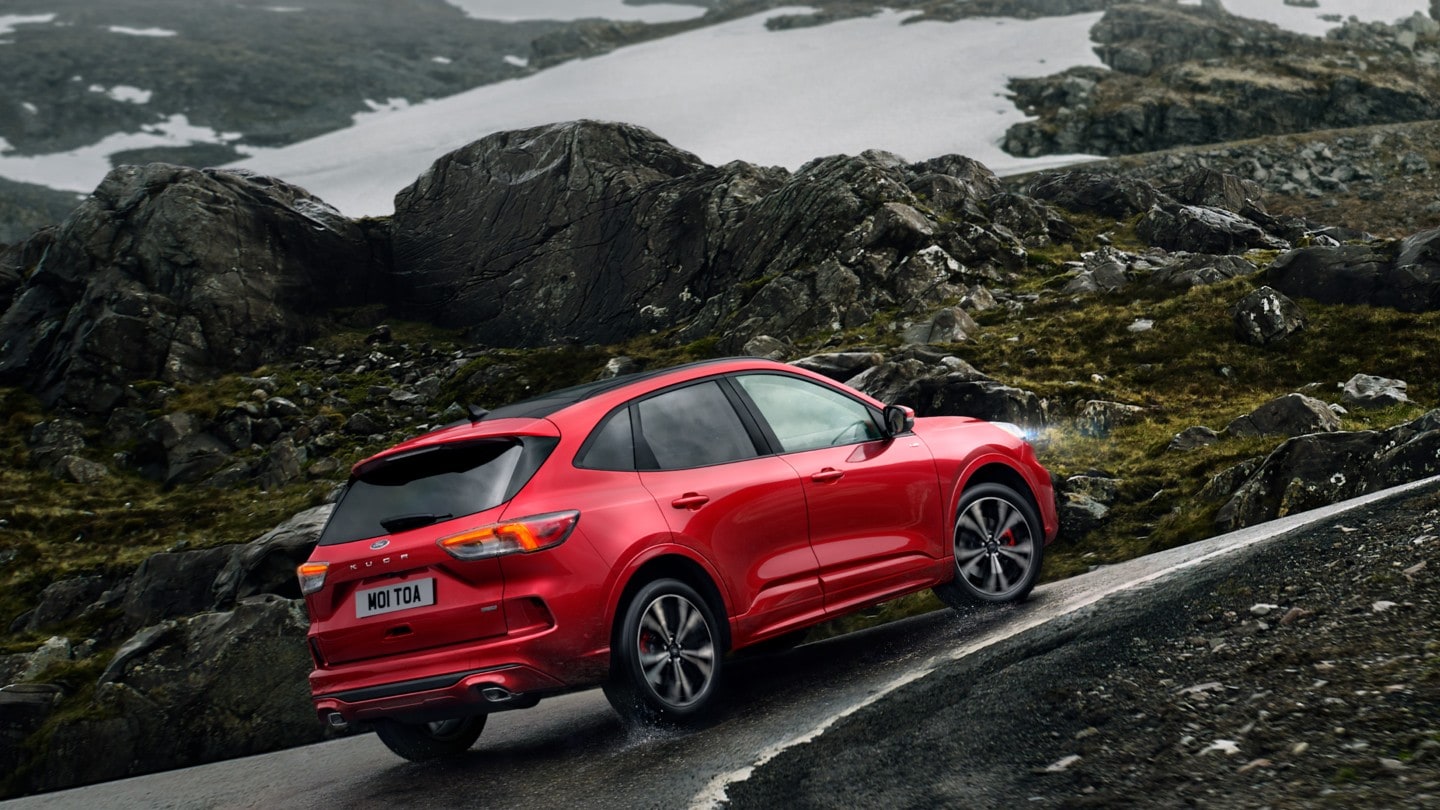 Red Ford Kuga driving along rocky curve