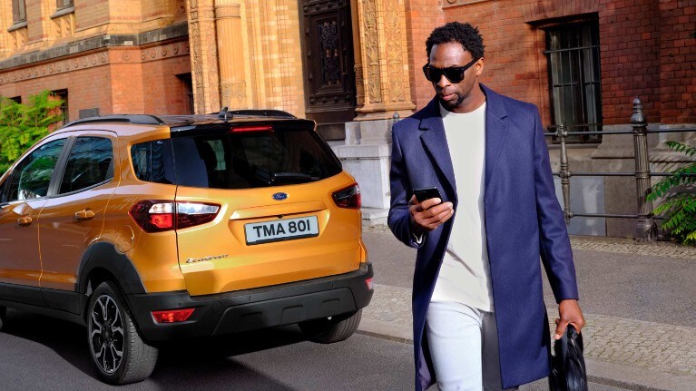 FordPass Connect - man next to Ford car checking his phone FordPass Connect - man next to Ford car checking his phone