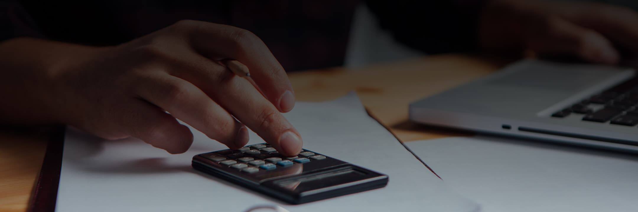 Close-up of a man's hand using a calculator