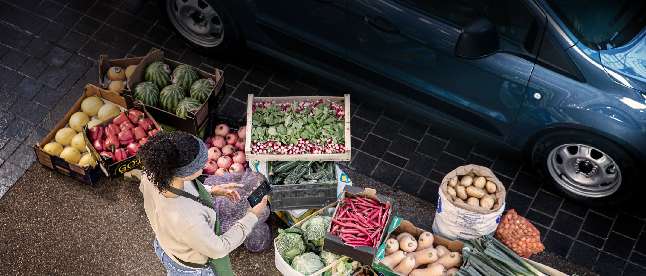 View from above of vegetable seller and boxes with vegetable