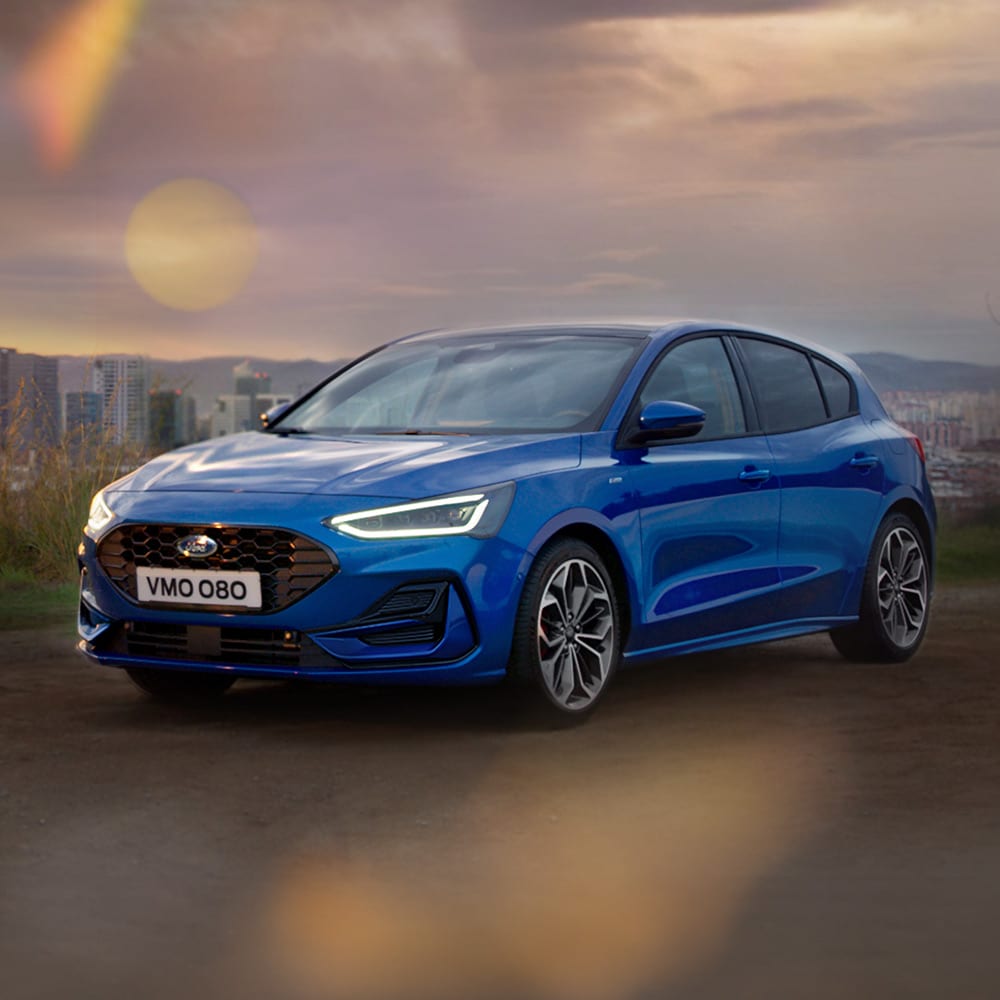 A blue Ford Focus parked on a bridge, with the five-star Euro NCAP safety rating badge in the bottom right corner.
