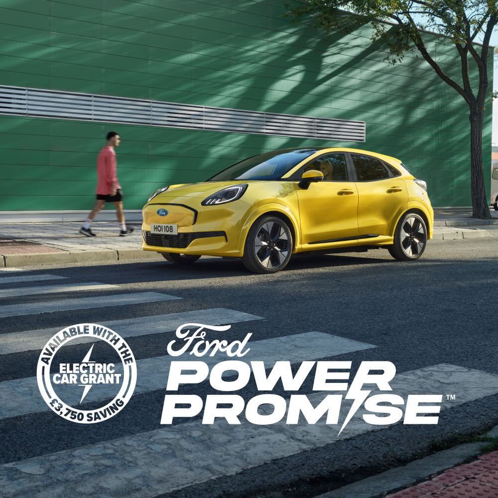 Side view of a yellow electric Ford Puma Gen-E® parked by the side of the road. Image features a Ford Power Promise logo.
