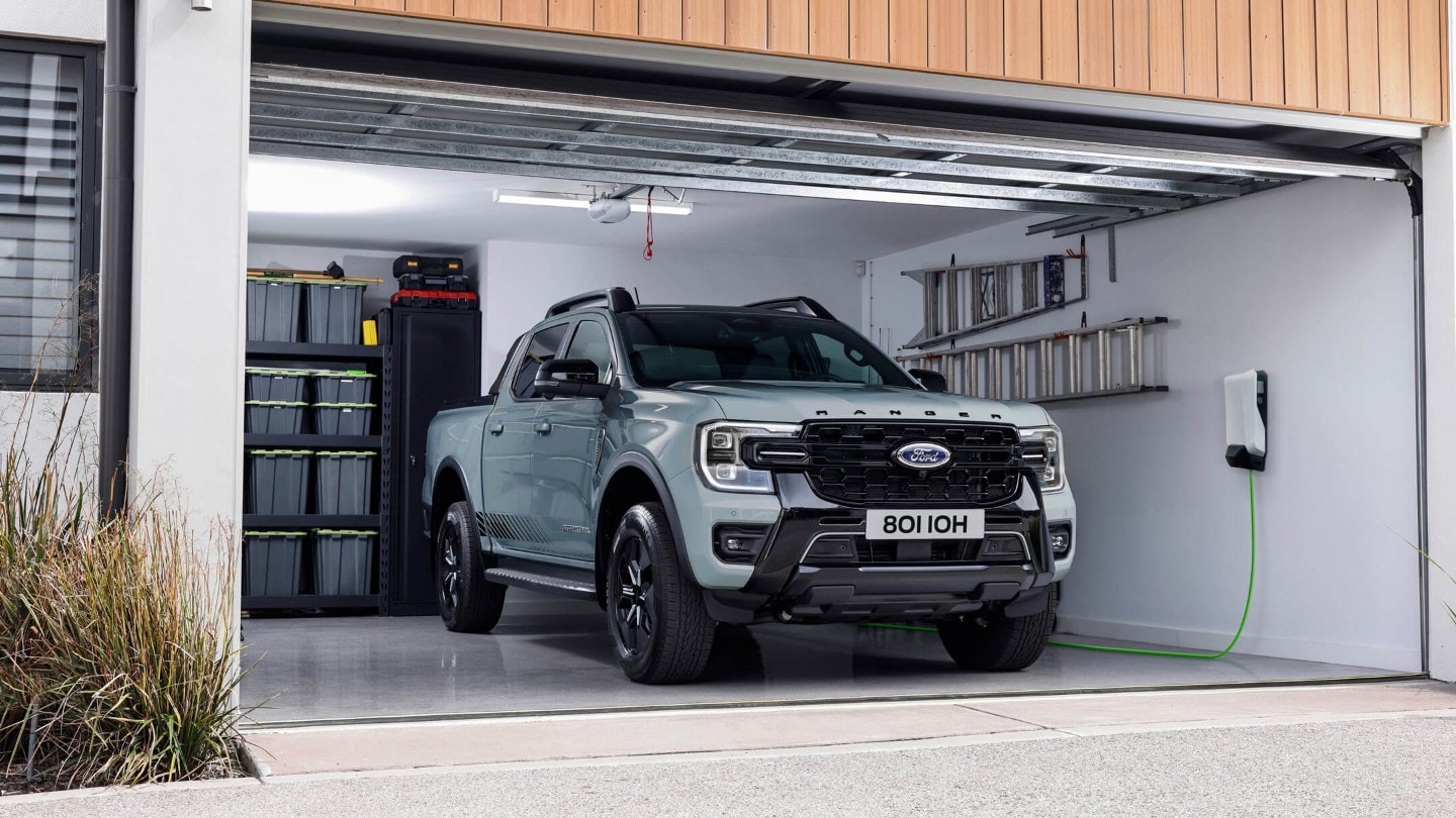 Ford Ranger PHEV parked in a garage with an EV charger on the wall