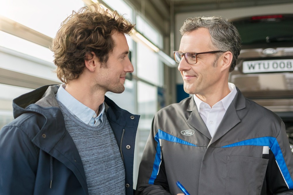 Ford repairman talking to a customer