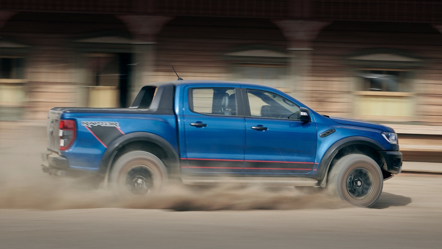 Blue Ford Raptor driving fast
