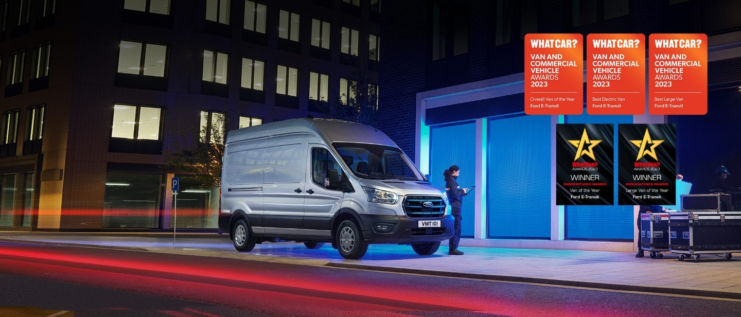 New Ford E-Transit in front of depot in city in night 3/4 front view