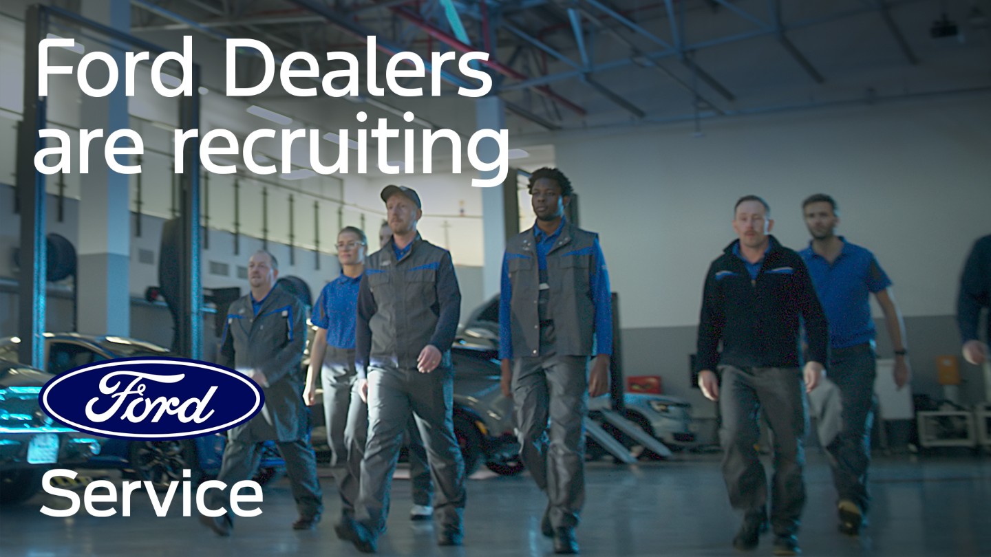 Ford technicians walk towards the camera in a dealership garage. The text "Ford Dealers are recruiting" and the Ford logo are displayed.