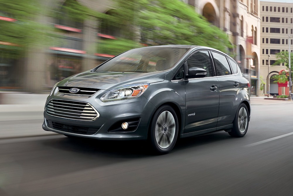 A grey Ford C-MAX driving through a city.