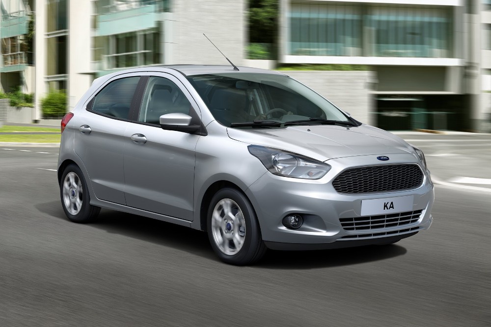 A silver Ford KA+ hatchback driving on an urban road.