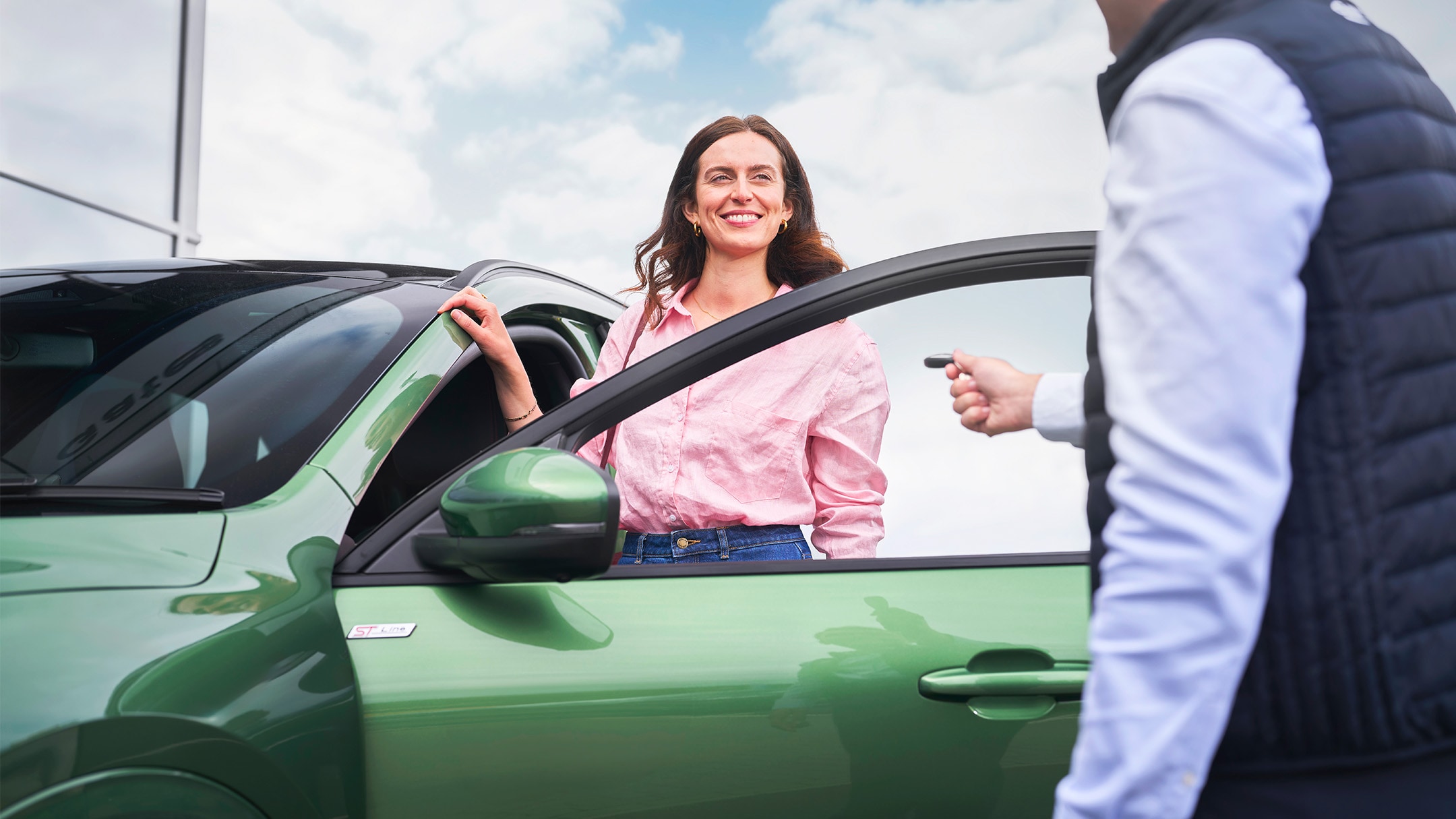 One man is giving car keys to the other one