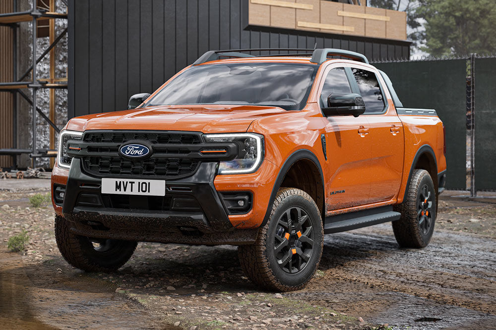 An orange Ford Ranger on a property construction site, seen from a front three-quarter angle.
