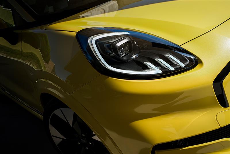 Front view of a yellow Ford Puma Gen-E, highlighting the headlight design and front quarter panel.